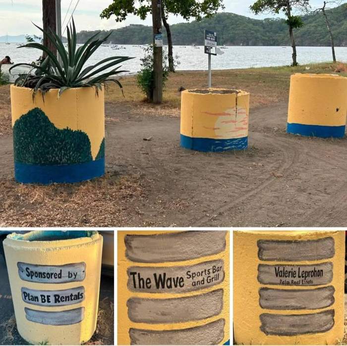 Painted concrete barrels with sponsor names.
